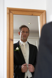 Find the Perfect Suits for the Groom and Groomsmen groom in mirror
